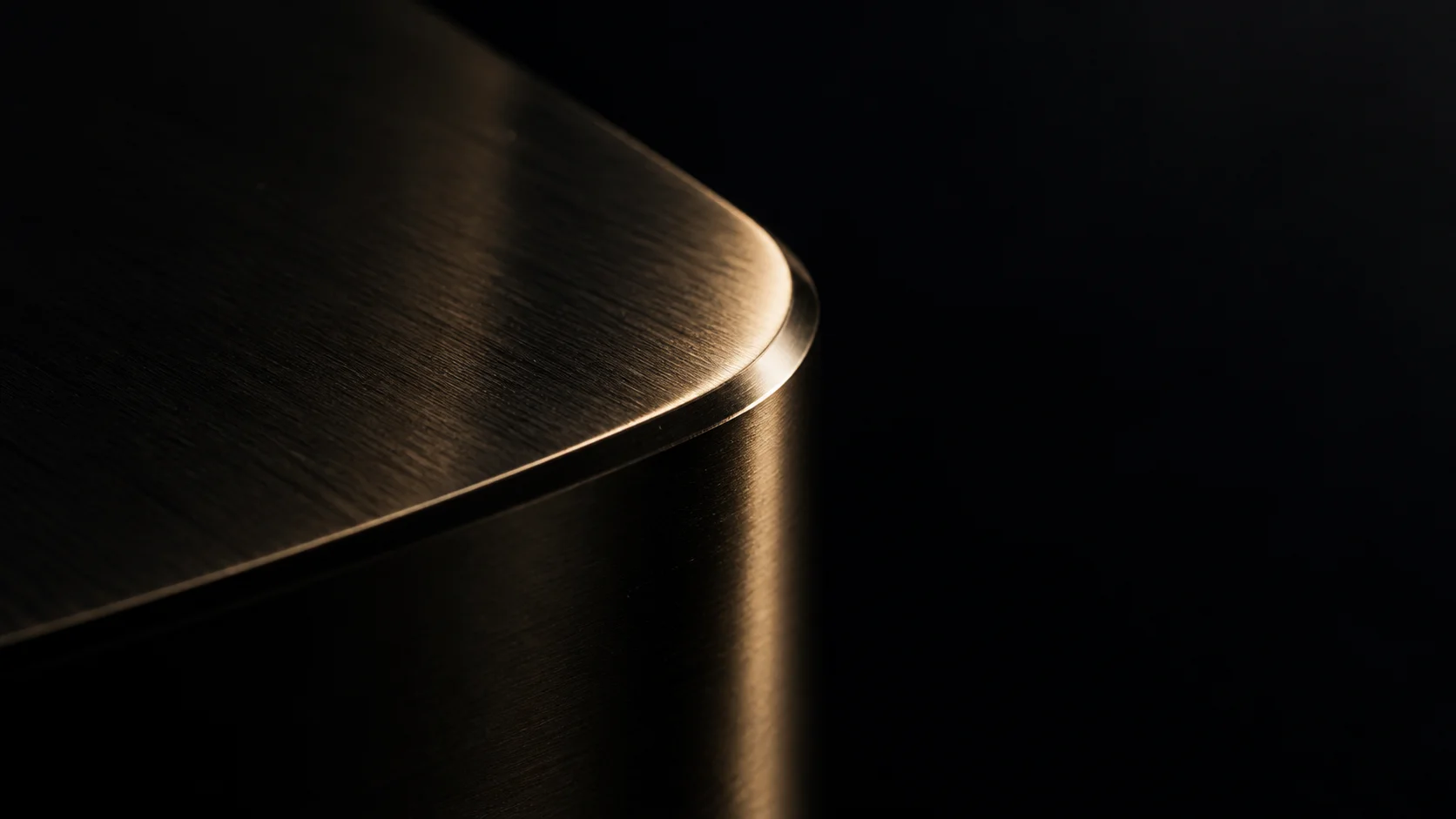 Une texture de métal noir parcourue de reflets champagne.