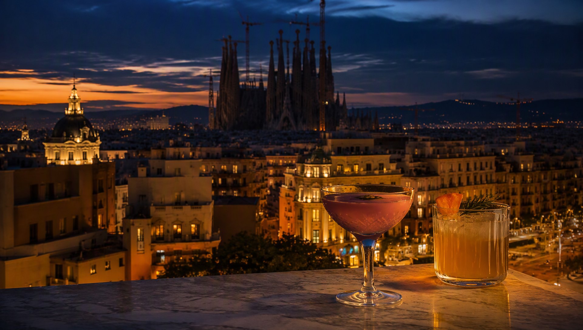 Barcelone au crépuscule depuis un rooftop, la Sagrada Família en silhouette.