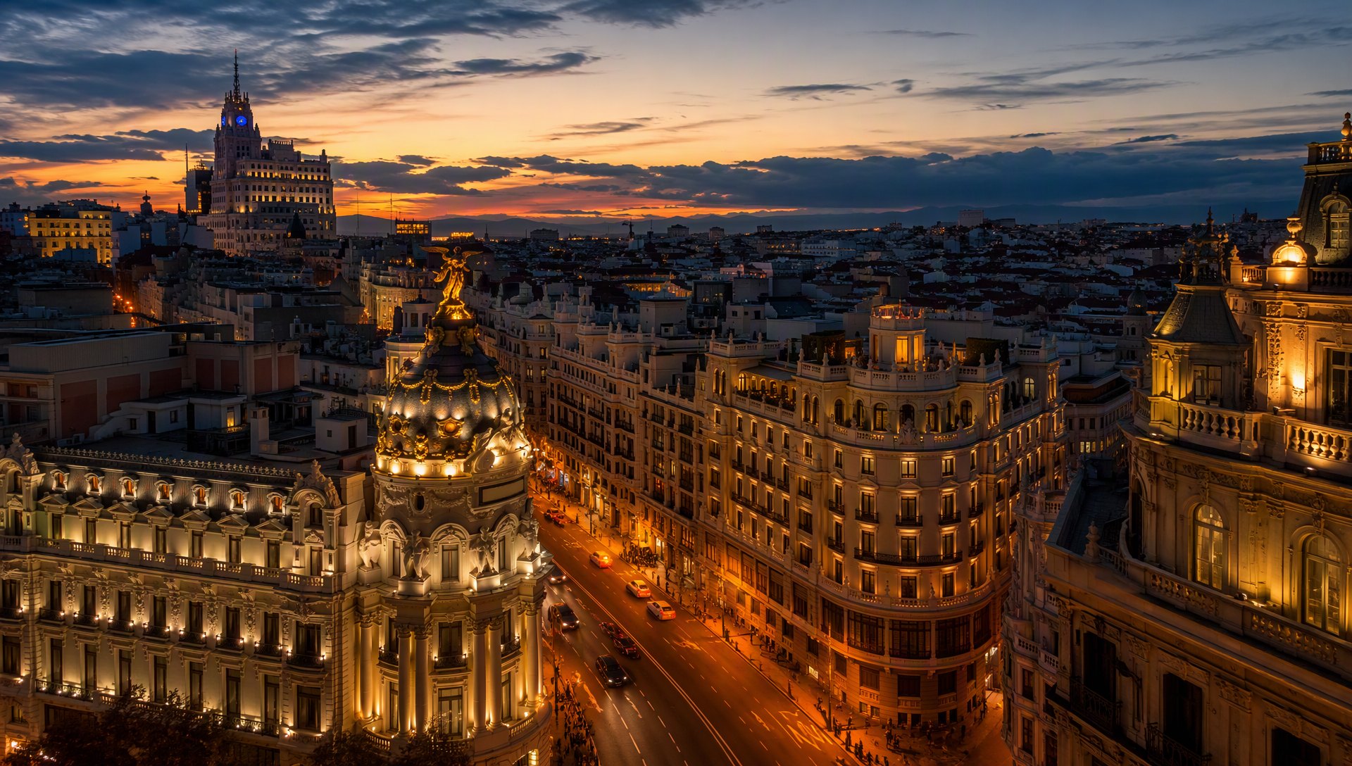 La Gran Vía de Madrid au crépuscule, façades Belle Époque illuminées.